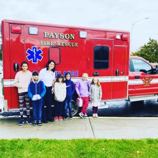 Winning students posing in front of the firetruck at the school.